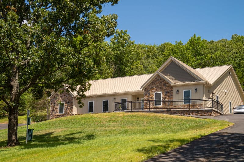Exterior of single story condo building with large lawn and driveway