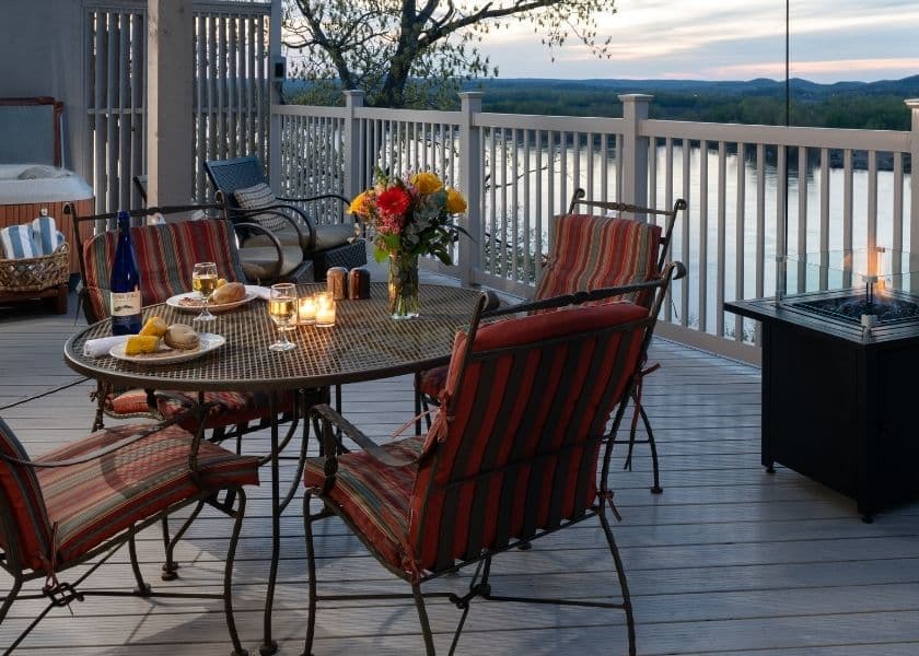 two plated meals, a bottle of wine, and two wine glasses on patio table on deck overlooking the missouri river two plated meals, a bottle of wine, and two wine glasses on patio table on deck overlooking the missouri river