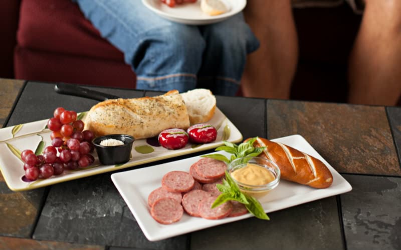 white plates holding bread, meat, cheese and spread