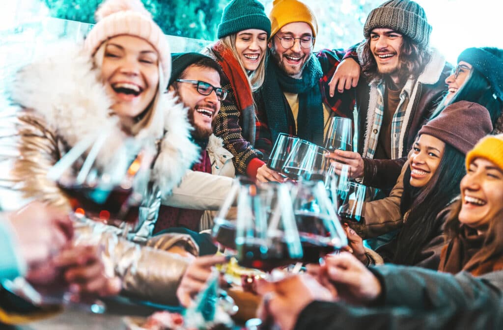 multiracial friends toasting wine in the winter