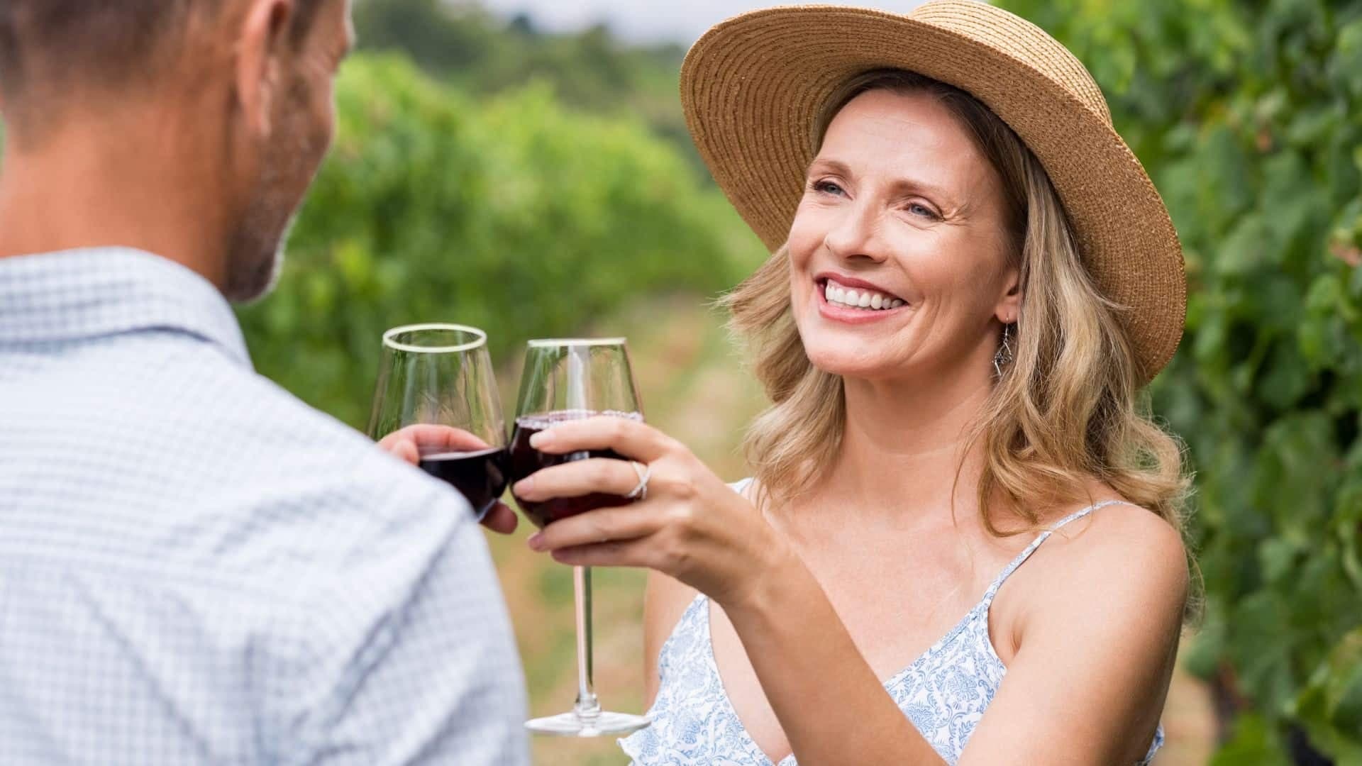 couple in a vineyard toasting with red wine